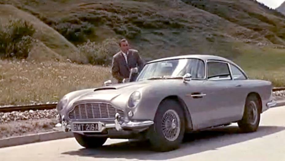 007 Contra Goldfinger (1964) - Na primeira incurs&atilde;o do ic&ocirc;nico Aston Martin DB5, no terceiro filme da s&eacute;rie, traquitanas como eixo abridor de latarias e &oacute;leo derram&aacute;vel na pista j&aacute; surpreendiam e divertiam as plat&eacute;ias. <a href="%20https://quatrorodas.abril.c" rel="migration"></a>