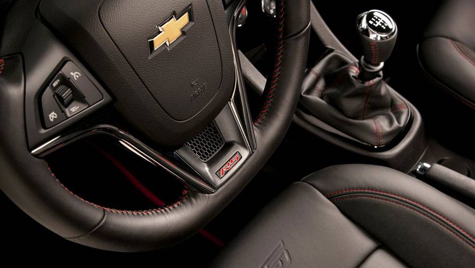 Logo tipo RS vem inscrito no volante | <a href="https://beta-develop.quatrorodas.abril.com.br/noticias/chevrolet-revela-imagens-sonic-rs-310416_p.shtml" rel="migration">Leia mais</a>