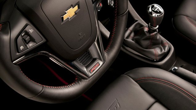 Logo tipo RS vem inscrito no volante | <a href="https://beta-develop.quatrorodas.abril.com.br/noticias/chevrolet-revela-imagens-sonic-rs-310416_p.shtml" rel="migration">Leia mais</a>