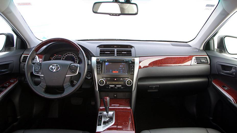 Interior luxuoso tem acabamento em madeira | <a href="https://beta-develop.quatrorodas.abril.com.br/carros/lancamentos/toyota-camry-2013-679638.shtml" rel="migration">Leia mais</a>