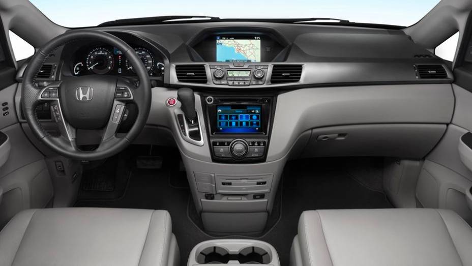 Por dentro, o console central foi renovado. Outros detalhes revistos foram o botão de acionamento do motor, central multimídia HondaLink (com integrações com smartphones)... | <a href="%20https://beta-develop.quatrorodas.abril.com.br/saloes/new-york/2013/honda-odyssey-73" rel="migration"></a>