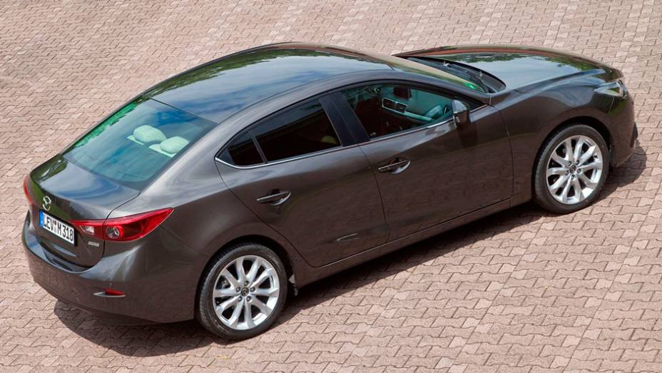 Novo Mazda3 Sedan parece um Mazda6 compacto, com um teto alongado e uma nova traseira mais atraente | <a href="https://beta-develop.quatrorodas.abril.com.br/noticias/fabricantes/primeiras-fotos-oficiais-mazda3-sedan-2014-sao-reveladas-745927.shtml" rel="migration">Leia mais</a>
