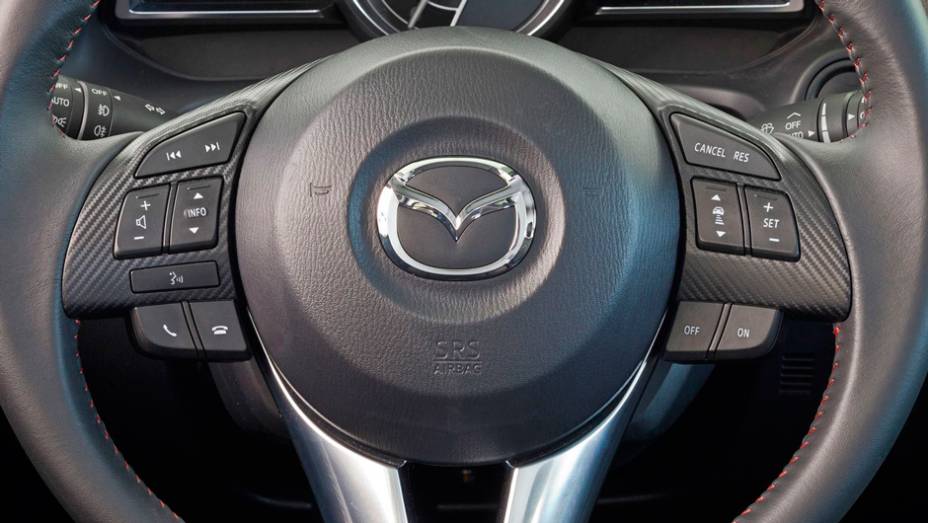 Detalhe do volante do novo Mazda3 Sedan | <a href="https://beta-develop.quatrorodas.abril.com.br/noticias/fabricantes/primeiras-fotos-oficiais-mazda3-sedan-2014-sao-reveladas-745927.shtml" rel="migration">Leia mais</a>