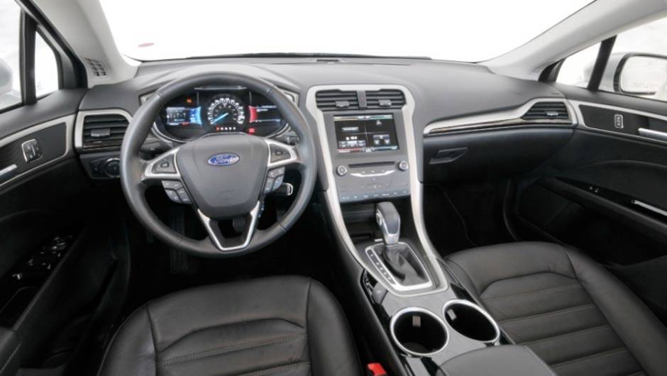 A cabine tem estilo moderno e clean, com todos os comandos ao alcance das m&atilde;os | <a href="https://beta-develop.quatrorodas.abril.com.br/carros/lancamentos/ford-fusion-2-5-flex-734482.shtml" rel="migration">Leia mais</a>