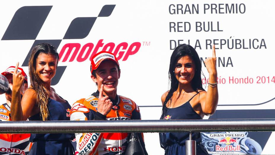M&aacute;rquez comemora com as belas grid girls. | <a href="https://beta-develop.quatrorodas.abril.com.br/moto/noticias/marquez-show-vence-terceira-ano-780924.shtml" rel="migration">Leia mais</a>