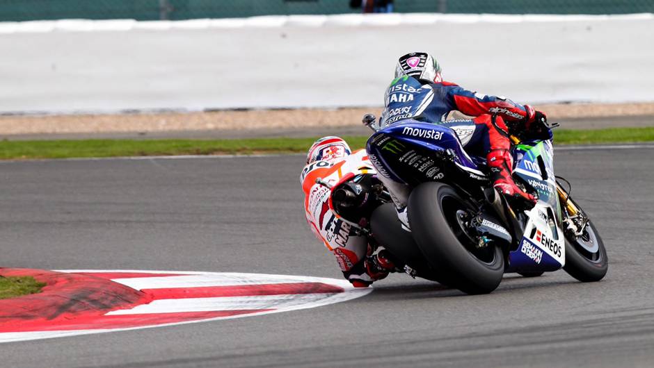 Momento crucial da prova: M&aacute;rquez ultrapassa Lorenzo, com direito a leve toque | <a href="https://beta-develop.quatrorodas.abril.com.br/moto/noticias/marquez-batalha-lorenzo-vence-gp-inglaterra-798447.shtml" rel="migration">Leia mais</a>