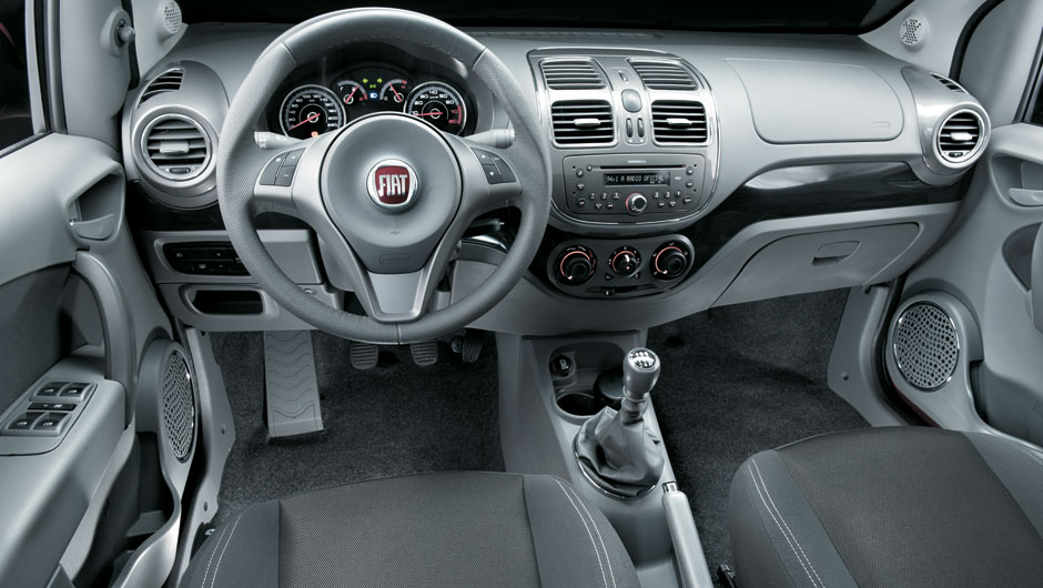 Estrutura do painel &eacute; do Palio, mas h&aacute; 4 sa&iacute;das de ar no centro | <a href="https://beta-develop.quatrorodas.abril.com.br/carros/testes/fiat-grand-siena-683966.shtml" rel="migration">Leia mais</a>