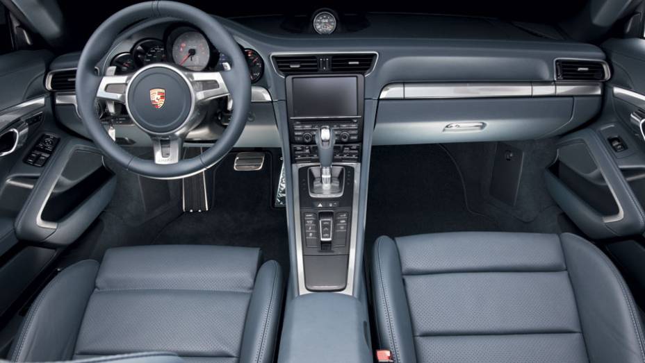 Tela de 7 polegadas sensível ao toque no console elevado mantém comandos à mão | <a href="https://beta-develop.quatrorodas.abril.com.br/carros/lancamentos/porsche-911-carrera-s-687122.shtml" rel="migration">Leia mais</a>