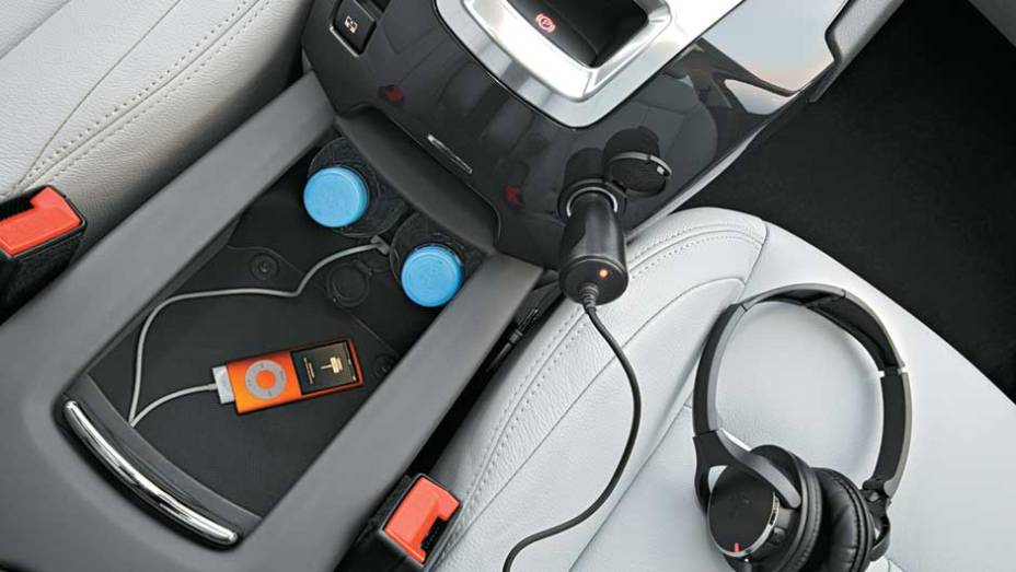Entrada para iPod, 2 tomadas de 12 V e porta-garrafa no centro | <a href="https://beta-develop.quatrorodas.abril.com.br/carros/impressoes/peugeot-5008-693468.shtml" rel="migration">Leia mais</a>