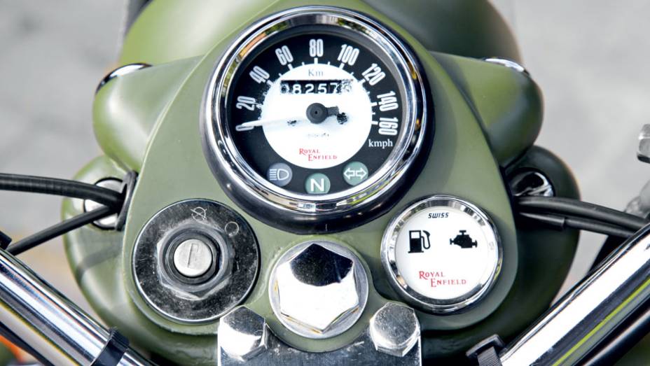 Velocímetro e luzes-espia encravados em peça que parece esculpida em um só bloco metálico | <a href="https://beta-develop.quatrorodas.abril.com.br/moto/testes/royal-enfield-classic-500-military-green-705420.shtml" rel="migration">Leia mais</a>