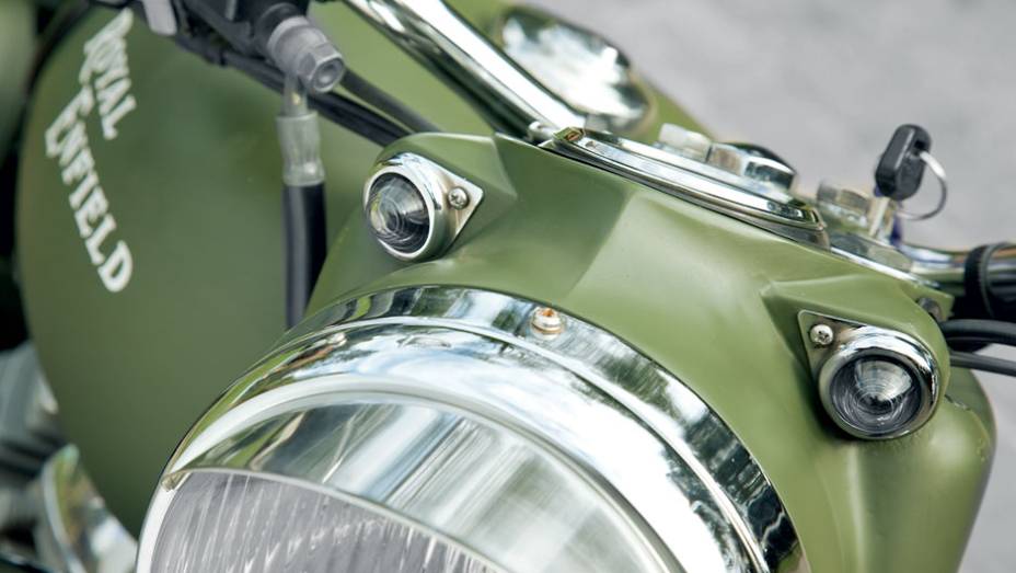 Luzes de posição sobre o farol são charme | <a href="https://beta-develop.quatrorodas.abril.com.br/moto/testes/royal-enfield-classic-500-military-green-705420.shtml" rel="migration">Leia mais</a>