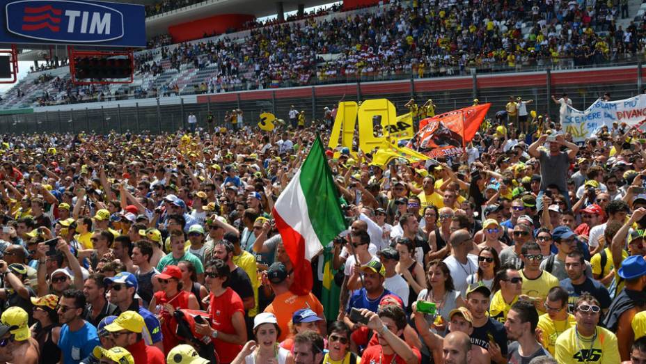 Torcida italiana invade pista após a dipsuta | <a href="https://beta-develop.quatrorodas.abril.com.br/moto/noticias/marquez-bate-lorenzo-briga-acirrada-garante-sexta-vitoria-784758.shtml" rel="migration">Leia mais</a>