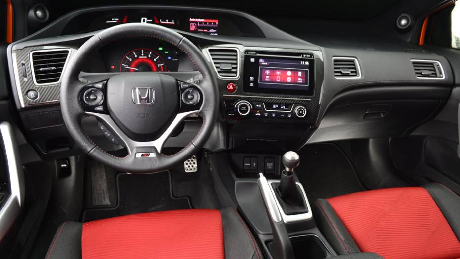 O interior lembra bastante o Civic sedã, mas traz acabamento exclusivo, com direito a detalhes em vermelho | <a href="https://beta-develop.quatrorodas.abril.com.br/carros/lancamentos/honda-civic-si-805295.shtml" rel="migration">Leia mais</a>