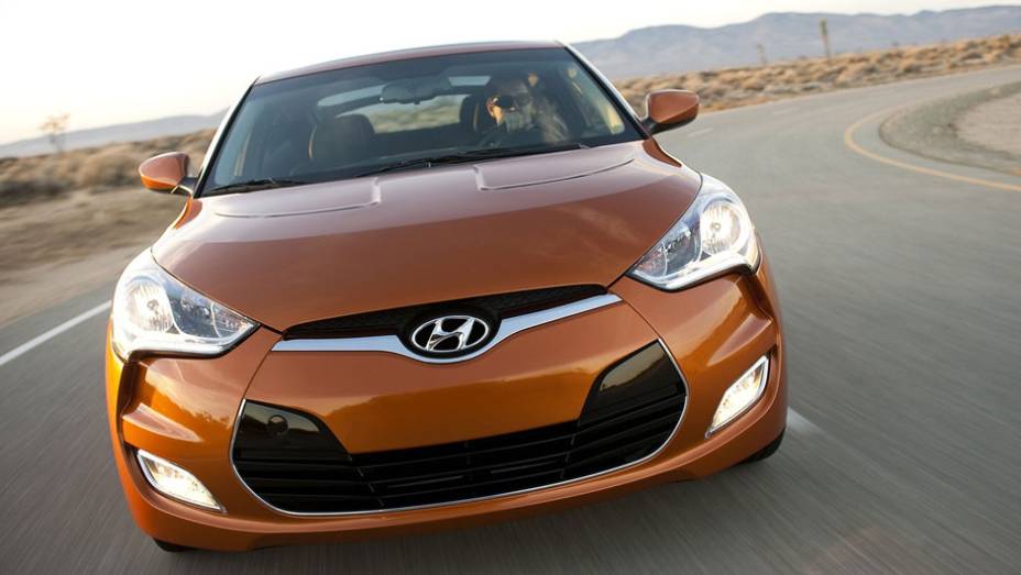 Linhas dinâmicas se unem ao aspecto musculoso do carro | <a href="https://beta-develop.quatrorodas.abril.com.br/carros/lancamentos/hyundai-veloster-641581.shtml" rel="migration">Leia mais</a>