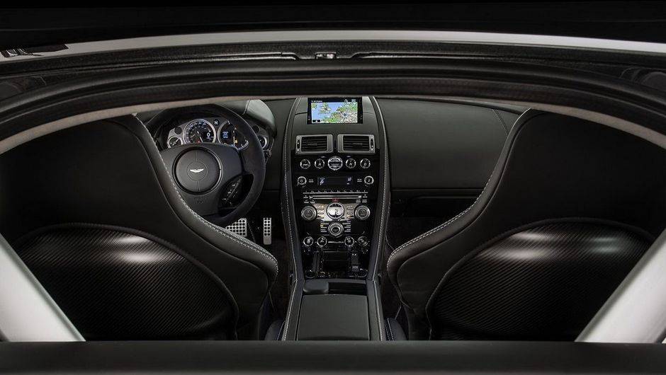 Por dentro, console central em Black Piano, sistema de som Premium Audio, bancos esportivos el&eacute;tricos, cruise control e conex&atilde;o Bluetooth | <a href="%20https://beta-develop.quatrorodas.abril.com.br/saloes/genebra/2013/aston-martin-vantage-v8-s-sp10-734797.shtml" rel="migration">Leia mai</a>