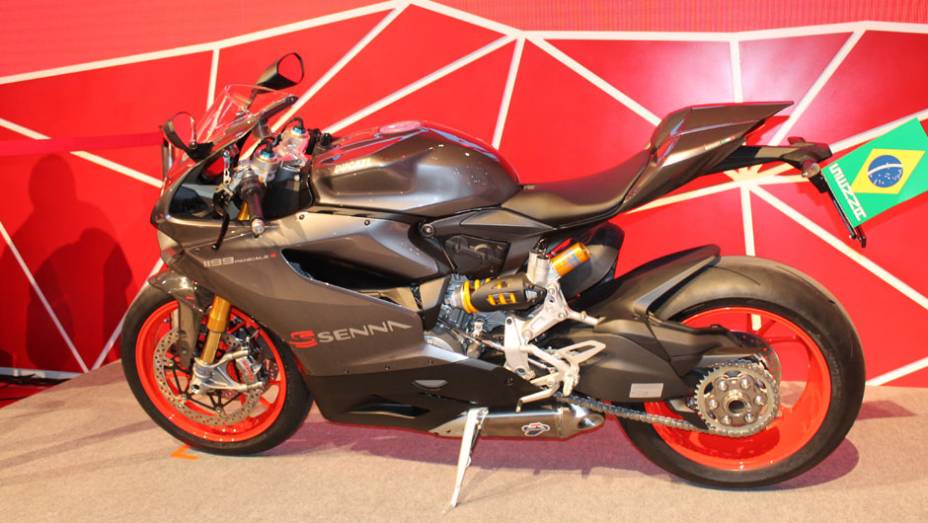 Tendo como base a esportiva Panigale, a moto conta com a cor especial "Cinza Senna" e diferentes grafismos | <a href="https://beta-develop.quatrorodas.abril.com.br/moto/noticias/ducati-revela-1199-panigale-s-senna-salao-duas-rodas-756467.shtml" rel="migration">Leia mais</a>