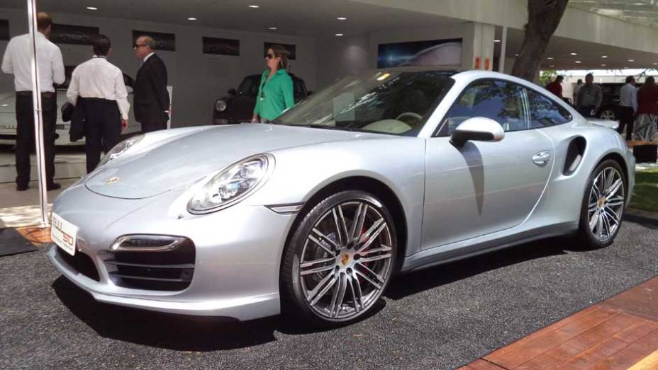 A Porsche exibe o 911 Turbo, vendido pela bagatela de 899 mil reais | <a href="https://beta-develop.quatrorodas.abril.com.br/noticias/fabricantes/auto-premium-show-abre-portas-sp-760626.shtml" rel="migration">Leia mais</a>