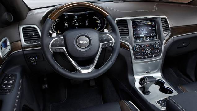 O volante de tr&ecirc;s raios tem comandos de som, piloto autom&aacute;tico e telefonia | <a href="https://beta-develop.quatrorodas.abril.com.br/carros/lancamentos/jeep-grand-cherokee-771722.shtml" rel="migration">Leia mais</a>