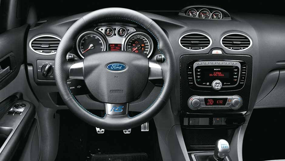 A sigla RS, no volante, vem de Rallye Sport. <a href="https://beta-develop.quatrorodas.abril.com.br/carros/impressoes/ford-focus-rs-636939.shtml" rel="migration">Leia mais</a> A sigla RS, no volante, vem de Rallye Sport. <a href="https://beta-develop.quatrorodas.abril.com.br/carros/impressoes/ford-focus-rs-636939.shtml" rel="migration">Leia mais</a>