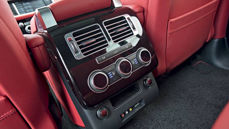 Atrás, um console abriga controles de ventilação e entrada auxiliar | <a href="https://beta-develop.quatrorodas.abril.com.br/carros/testes/land-rover-range-rover-vogue-738240.shtml" rel="migration">Leia mais</a>