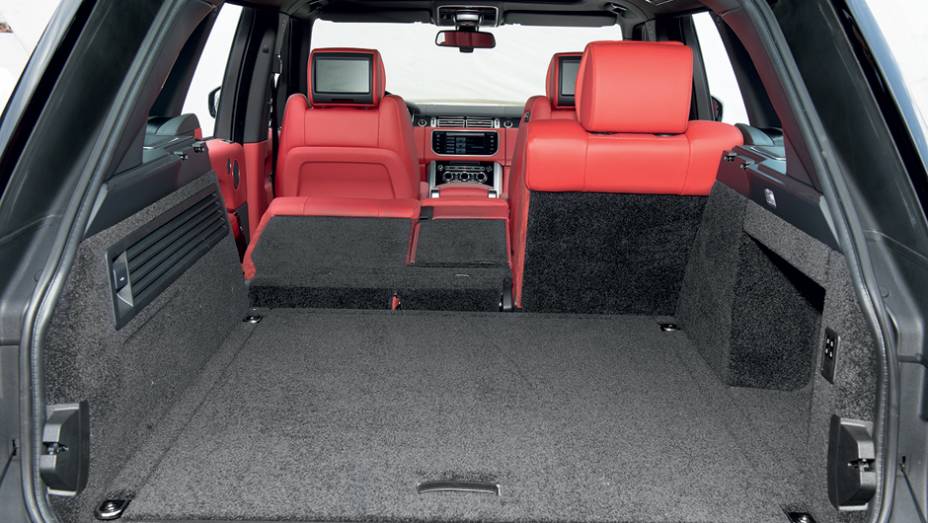 Porta-malas tem tampa elétrica e bot&atilde;o na lateral para rebater os bancos | <a href="https://beta-develop.quatrorodas.abril.com.br/carros/testes/land-rover-range-rover-vogue-738240.shtml" rel="migration">Leia mais</a>