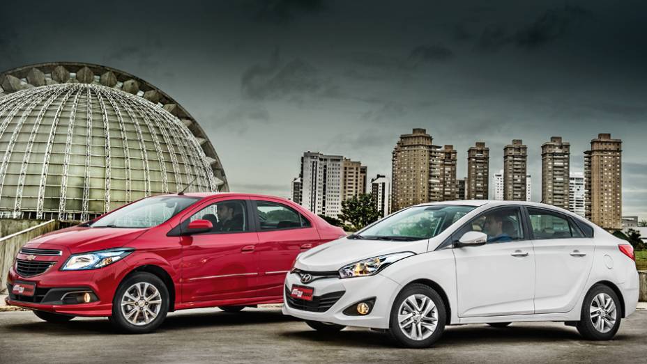 Prisma e HB20S: frente a frente no show de calouros | <a href="https://beta-develop.quatrorodas.abril.com.br/carros/comparativos/chevrolet-prisma-ltz-x-hyundai-hb20s-premium-740129.shtml" rel="migration">Leia mais</a>