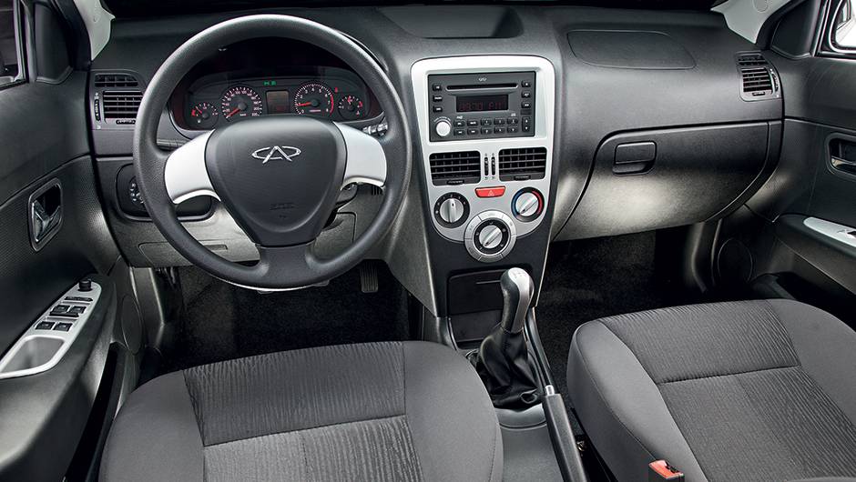 Molduras em console, volante e portas t&ecirc;m um tom de prata diferente do aplique do c&acirc;mbio | <a href="https://beta-develop.quatrorodas.abril.com.br/carros/comparativos/jac-j3-1-5-s-x-chery-celer-1-5-744920.shtml" rel="migration">Leia mais</a>