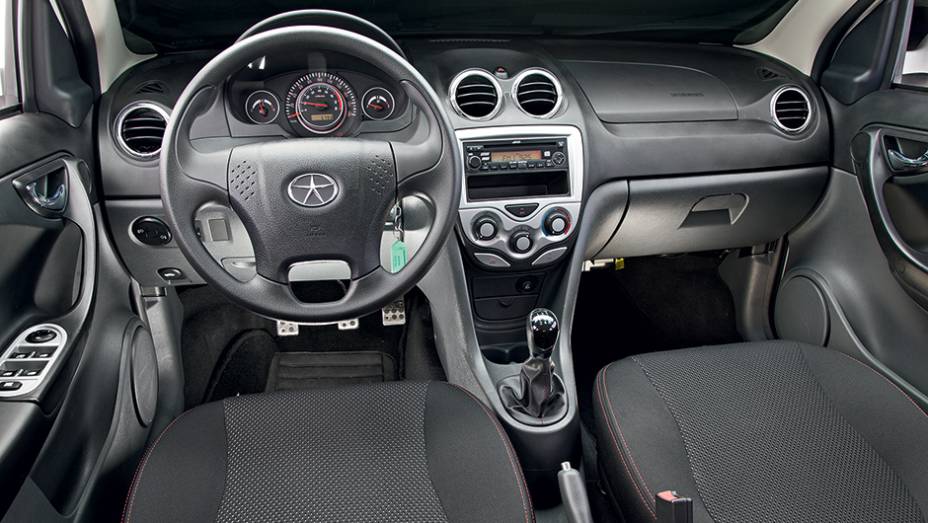Volante de quatro raios e sa&iacute;das de ventila&ccedil;&atilde;o t&ecirc;m detalhes cromados | <a href="https://beta-develop.quatrorodas.abril.com.br/carros/comparativos/jac-j3-1-5-s-x-chery-celer-1-5-744920.shtml" rel="migration">Leia mais</a>