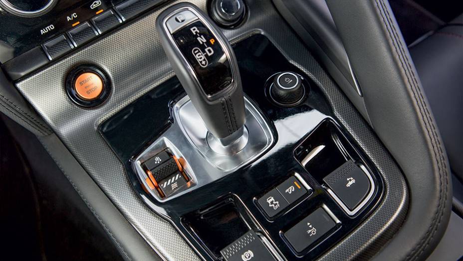 Além do câmbio, o console reúne as teclas do sistema de gestão dinâmica, do freio de estacionamento, do ESP, do sistema sonoro do escapamento, do acionamento do aerofólio e da capota elétrica | <a href="https://beta-develop.quatrorodas.abril.com.br/carros/testes/jaguar" rel="migration"></a>