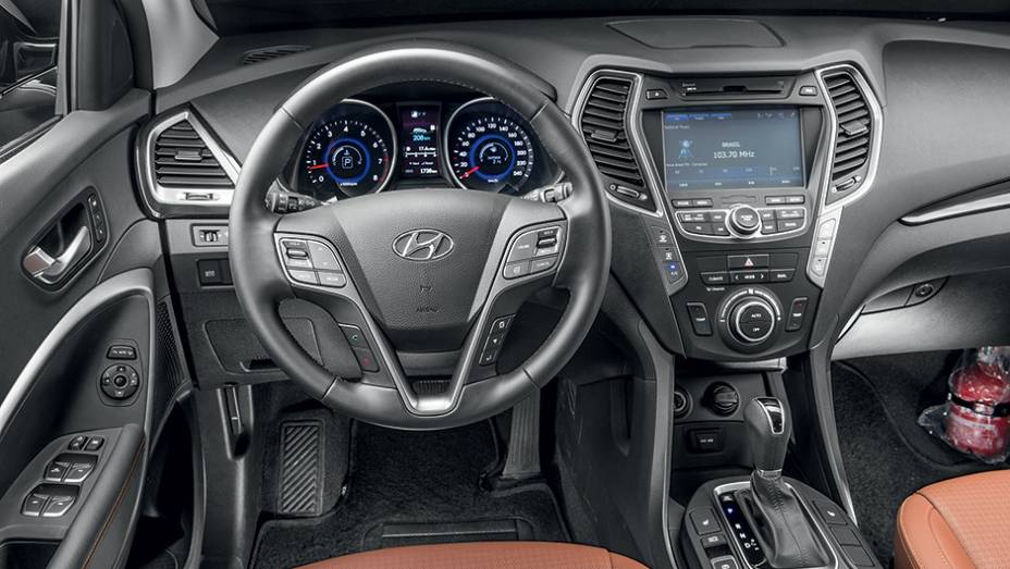 Interior caprichado é repleto de comandos. Há até um certo exagero de informações | <a href="https://beta-develop.quatrorodas.abril.com.br/carros/impressoes/hyundai-santa-fe-7-lugares-759289.shtml" rel="migration">Leia mais</a>