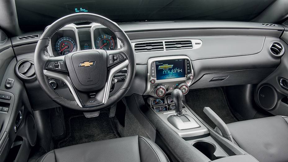 Os mostradores redondos com molduras quadradas remetem à primeira versão do Camaro | <a href="https://beta-develop.quatrorodas.abril.com.br/carros/testes/chevrolet-camaro-ss-763989.shtml" rel="migration">Leia mais</a> Os mostradores redondos com molduras quadradas remetem à primeira versão do Camaro | <a href="https://beta-develop.quatrorodas.abril.com.br/carros/testes/chevrolet-camaro-ss-763989.shtml" rel="migration">Leia mais</a>