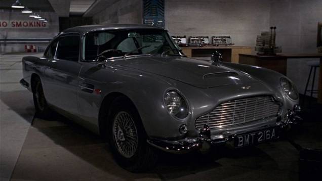 1964: O mais famoso ve&iacute;culo utilizado pelo espi&atilde;o estreia em "007 contra Goldfinger": o Aston Martin DB5. | <a href="%20https://beta-develop.quatrorodas.abril.com.br/blogs/planeta-carro/2012/11/07/licenca-para-acelerar/" rel="migration">Leia mais</a>