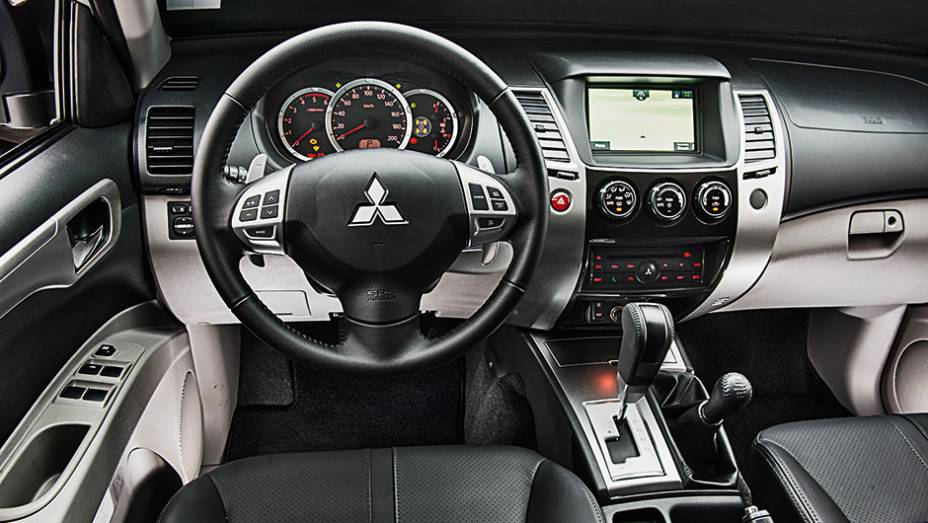 Bancos de couro e console central com acabamento que imita tit&acirc;nio | <a href="https://beta-develop.quatrorodas.abril.com.br/carros/testes/mitsubishi-pajero-dakar-hpe-765655.shtml" rel="migration">Leia mais</a>