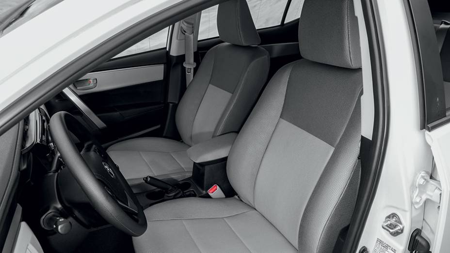 … estofamento de tecido são exclusivos da versão de entrada | <a href="https://beta-develop.quatrorodas.abril.com.br/carros/testes/toyota-corolla-gli-1-8-783149.shtml" rel="migration">Leia mais</a>