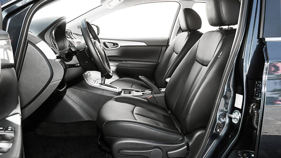 Interior do Nissan tem cores escuras | <a href="https://beta-develop.quatrorodas.abril.com.br/carros/comparativos/sedas-medios-783295.shtml" rel="migration">Leia mais</a>