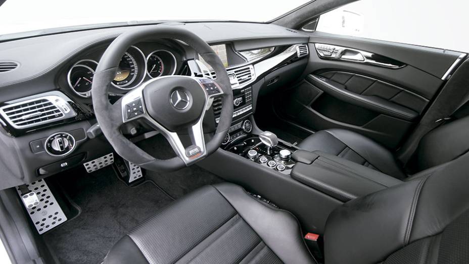 Interior personalizado inclui pedaleiras, volante e grandes borboletas atrás do volante, todos com a marca da empresa | <a href="https://beta-develop.quatrorodas.abril.com.br/carros/impressoes/brabus-cls-787697.shtml" rel="migration">Leia mais</a>