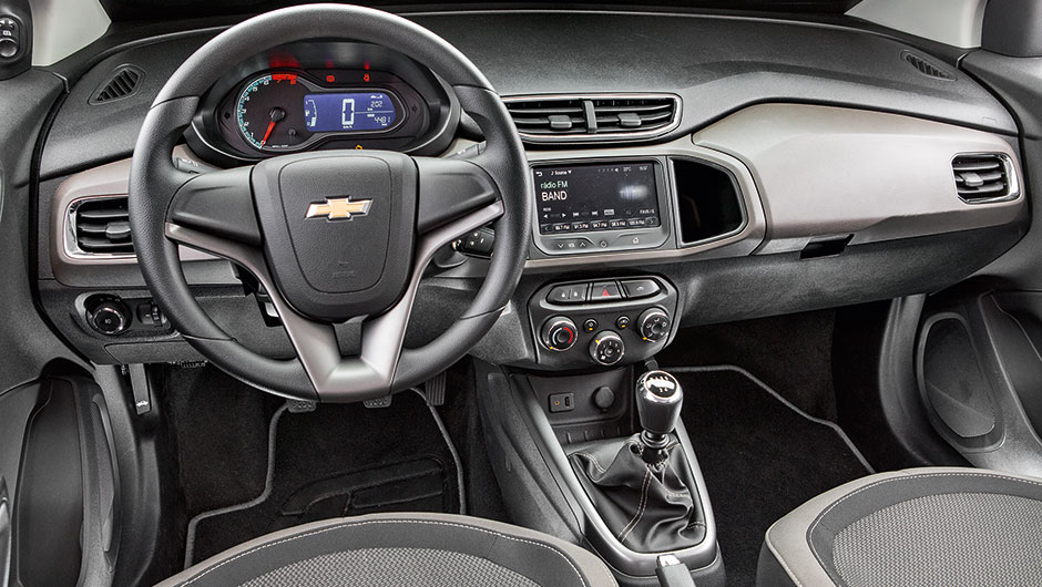 O acabamento do painel recebe duas cores e os bancos, tecido em relevo | <a href="https://beta-develop.quatrorodas.abril.com.br/carros/comparativos/ka-x-prisma-x-voyage-x-grand-siena-806201.shtml" target="_blank" rel="migration">Leia mais</a>