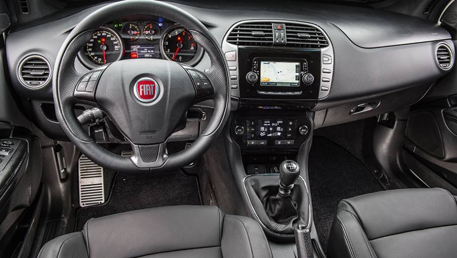 Textura na parte frontal lembra fibra de carbono. No console, o plástico segue o padrão piano black | <a href="https://beta-develop.quatrorodas.abril.com.br/carros/comparativos/comparativo-esportivos-841704.shtml" target="_blank" rel="migration">Leia mais</a>