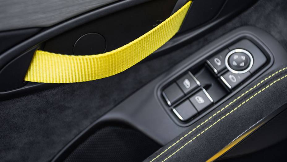 Tira de tecido como ma&ccedil;aneta comp&otilde;e visual esportivo interno | <a href="https://beta-develop.quatrorodas.abril.com.br/carros/impressoes/porsche-cayman-gt4-855525.shtml" target="_blank" rel="migration">Leia mais</a>
