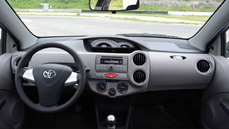 O interior tem materiais simples, como todo popular, e painel em posição central | <a href="https://beta-develop.quatrorodas.abril.com.br/salao-do-automovel/2012/carros/toyota-etios-703992.shtml" rel="migration">Leia mais</a>