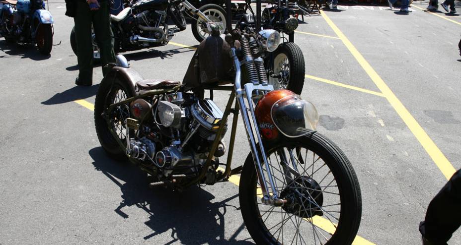 Chopper ao estilo Rat Bike (com aspecto enferrujado) com pedal de partida simulando um de bicicleta, selim fino, rabo duro e motor H-D flathead | <a href="https://beta-develop.quatrorodas.abril.com.br/moto/noticias/two-wheels-brazil-reune-fabricantes-nacionais-americano" rel="migration"></a>