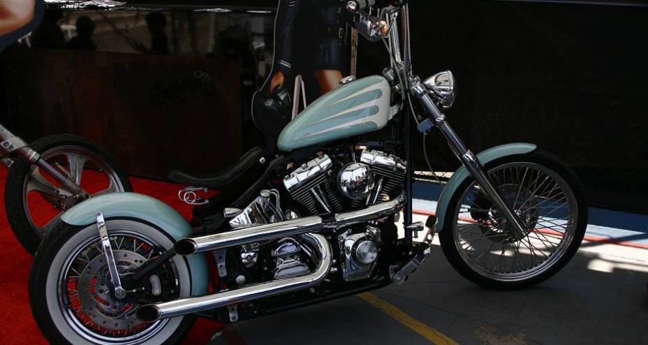 H-D customizada com motor, tanque de óleo, escapes e filtro de ar cromados, para-lama isolado na roda traseira e selin com molas | <a href="https://beta-develop.quatrorodas.abril.com.br/moto/noticias/two-wheels-brazil-reune-fabricantes-nacionais-americanos-motos-vintage" rel="migration"></a>