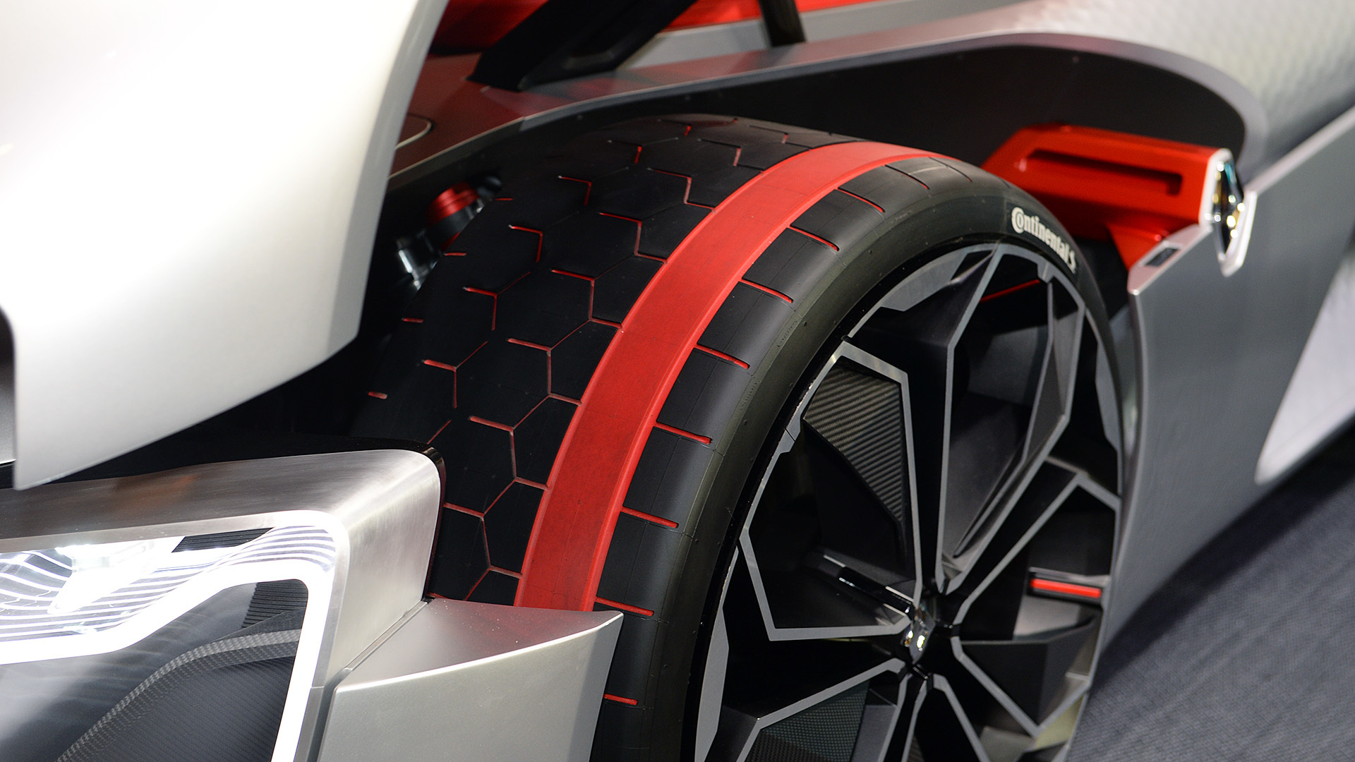 Pneu da Continental, feito sob encomenda. Exibe uma faixa vermelha na banca de rodagem. E sulcos vermelhos em hex&aacute;gonos