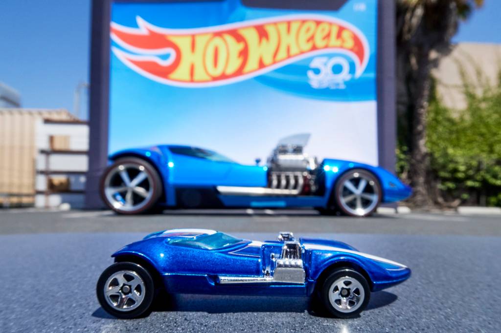 Photographer David Chickering Modelo azul atrás de uma miniatura Hot Wheels azul vista de lado