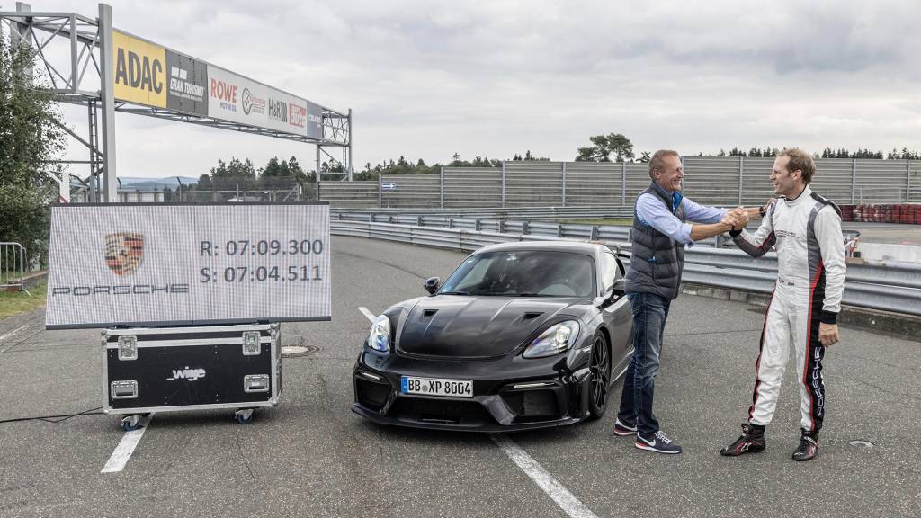 PORSCHE 718 CAYMAN GT4 RS Porsche 718 Cayman GT4 RS 2022 preto visto 3/4 de frente com o piloto e tempo de volta