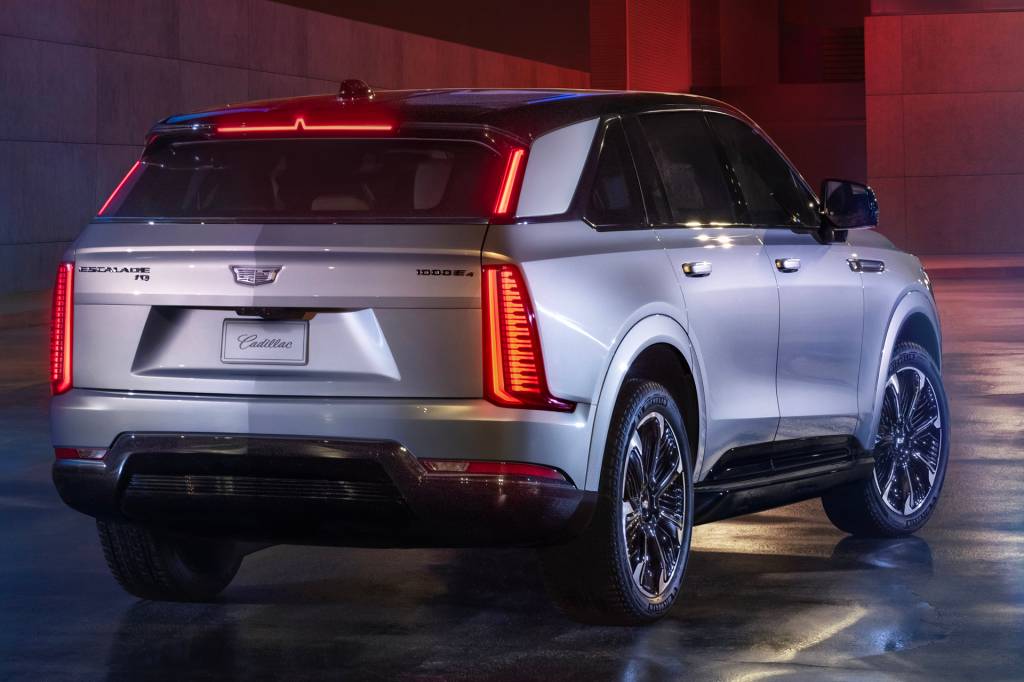 2025 Cadillac ESCALADE IQ Sport Rear 7/8 view of Cadillac ESCALADE IQ Sport in Flare Metallic at night.