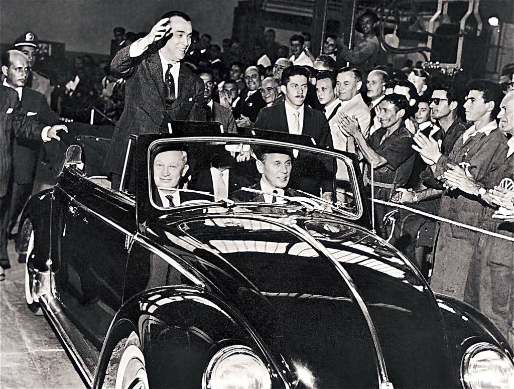 WhatsApp Image 2024-02-02 at 17.14.00 Juscelino Kubitschek acenando num Fusca conversível, conduzido por Henrich Nordhoff, presidente do grupo Volkswagen, no banco de passageiros, e Wilhelm Shultz-Wenk, presidente da Volkswagen no Brasil, ao volante