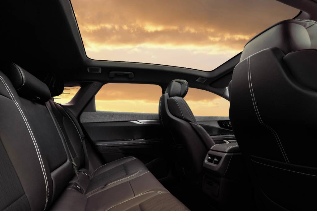 2025 Cadillac OPTIQ View of 2025 Cadillac OPTIQ interior showing the second-row seating with segment-best spaciousness and fixed glass roof.