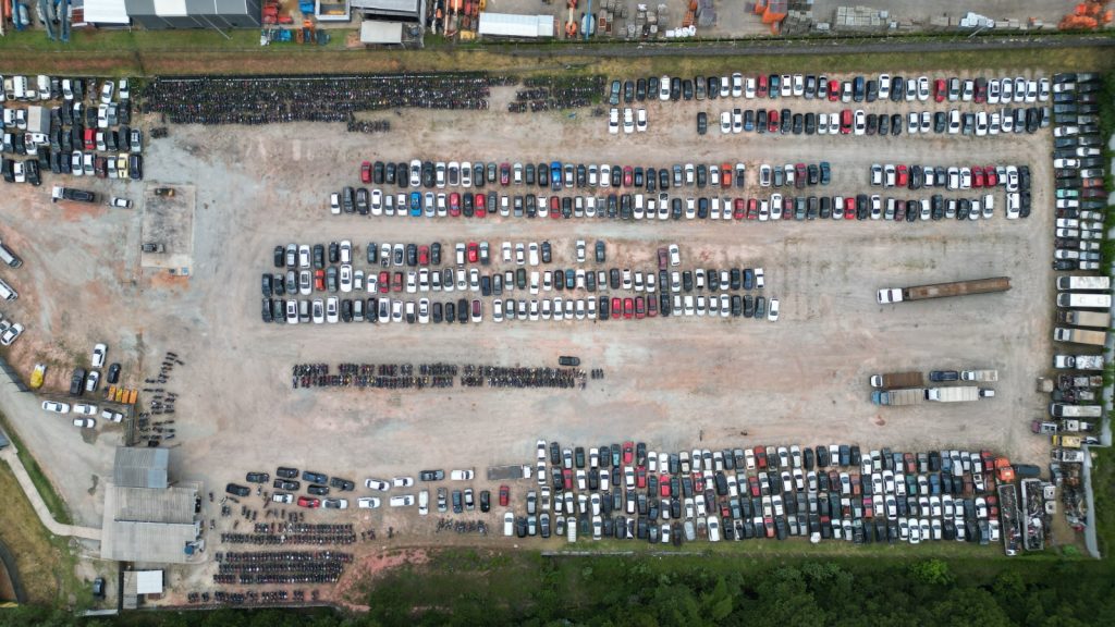 Ve&iacute;culos estacionados em p&aacute;tio