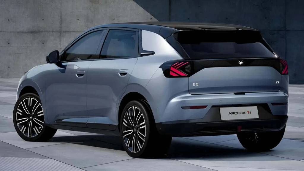 Carro ArcFox T1 cinza-azulado, com teto preto e rodas esportivas pretas e brancas, estacionado em piso de concreto claro com parede cinza ao fundo